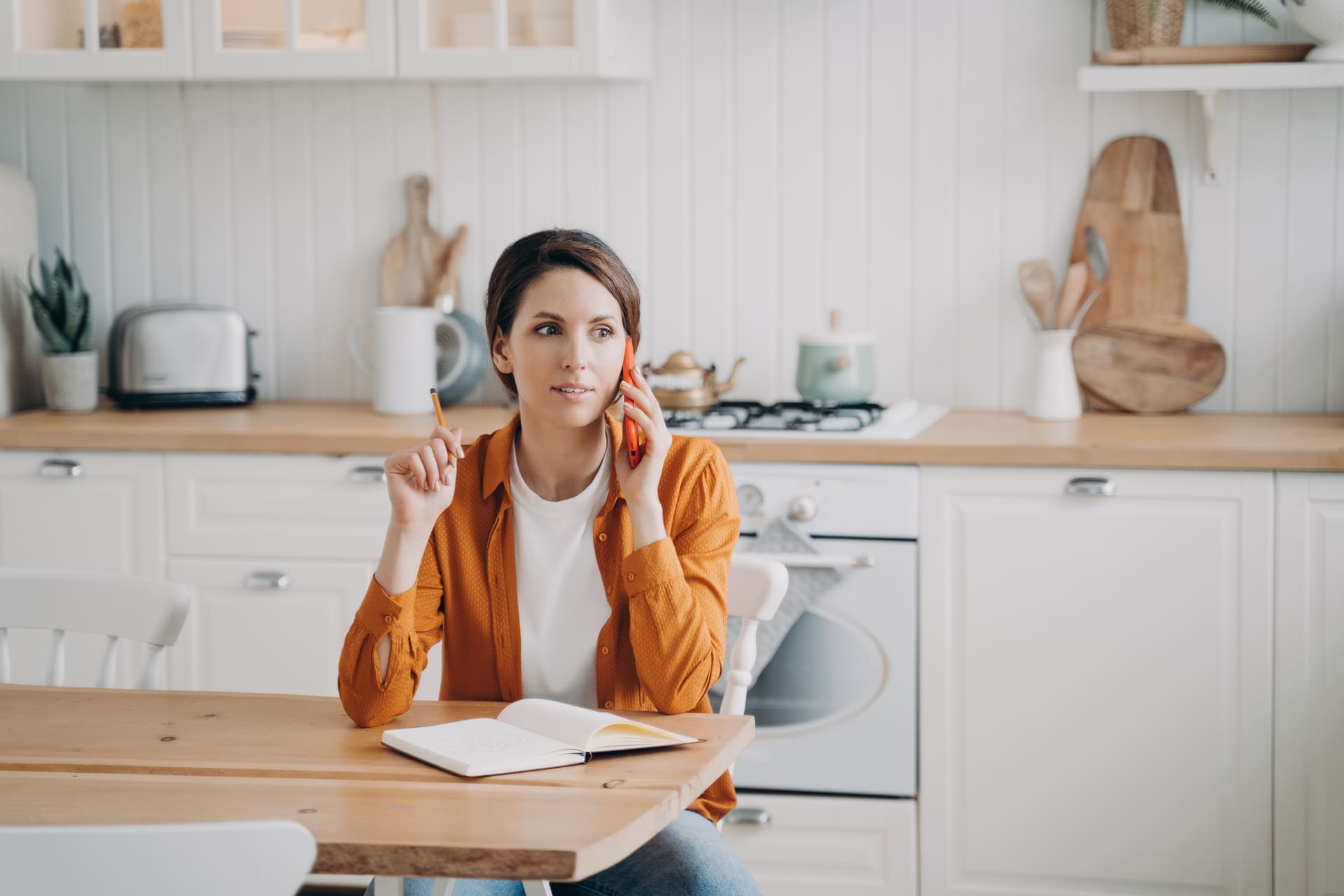 A woman sitting at the table in her kitchen.